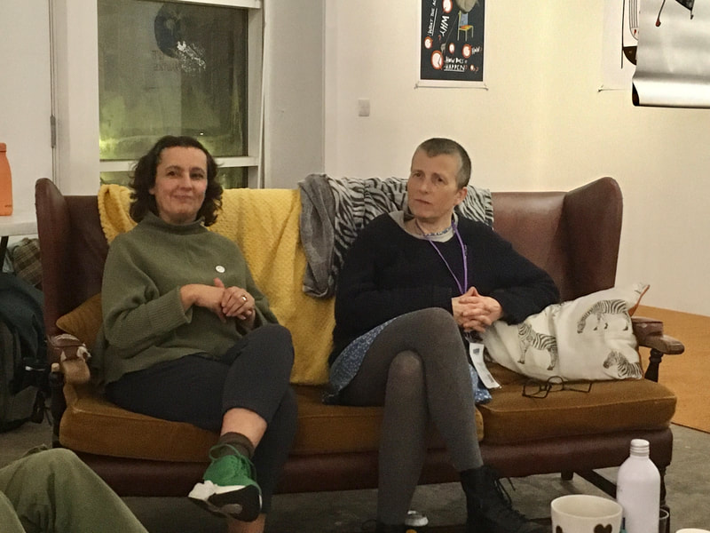 2 women sitting side by side on a sofa